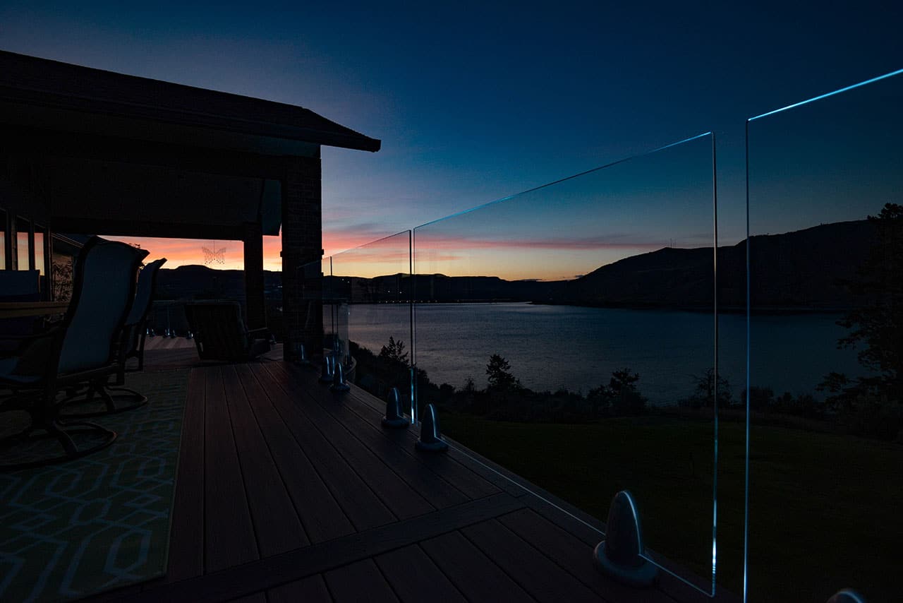 frameless glass deck railing at dusk